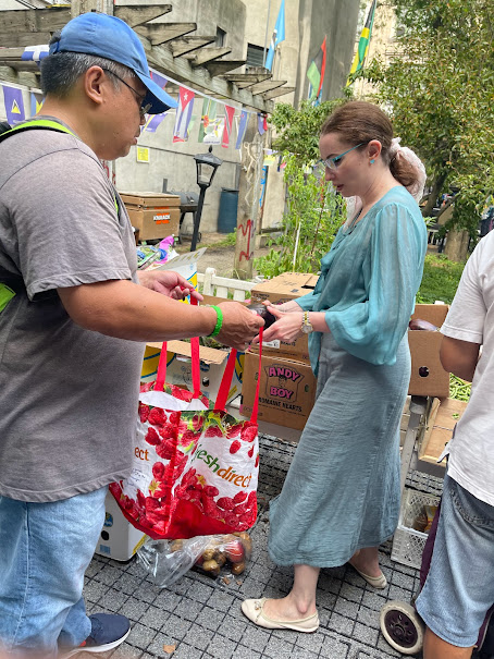 Older woman carrying strawberries and blue tote bags after receiving support